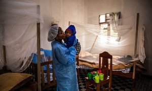 A caregiver at the Ebola Treatment Centre of Butembo, kisses a seven-month-old baby whose mother died of the Ebola just days earlier. North Kivu, Democratic Republic of Congo, 23 March 2019.