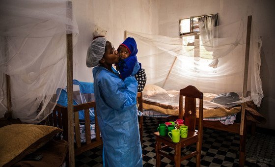 Um cuidador no Centro de Tratamento Ebola de Butembo, beija um bebê de sete meses que perdeu a mãe devido ao ebola poucos dias antes.