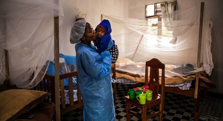 Um cuidador no Centro de Tratamento Ebola de Butembo, beija um bebê de sete meses que perdeu a mãe devido ao ebola poucos dias antes.