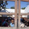 Cyclones Idai and Kenneth in Mozambique. In Beira, a boy looks through a classroom window.