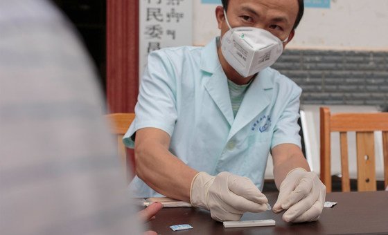 Investigador na China demonstra o uso de um teste de diagnóstico rápido de malária