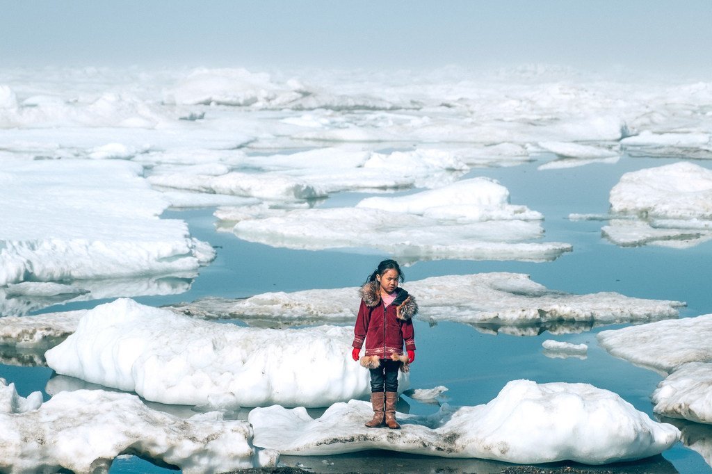 Une jeune fille de la communauté Iñupiat sur une banquise sur une rive de l'océan Arctique à Barrow, en Alaska. La fonte anormale des glaces de l'Arctique est l'un des nombreux effets du réchauffement climatique qui a de graves répercuss