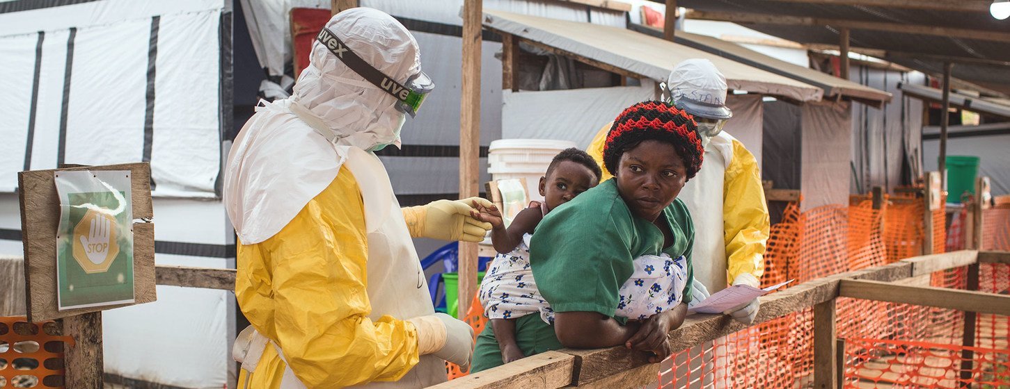 Un travailleur de santé en tenue de protection examine un enfant au Centre de traitement de l'Ebola à Beni, en République démocratique du Congo.