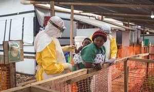 2019年3月24日，一名卫生工作者在刚果民主共和国北基伍省的贝尼埃博拉治疗中心对一名可能感染埃博拉病毒的儿童进行检查。 