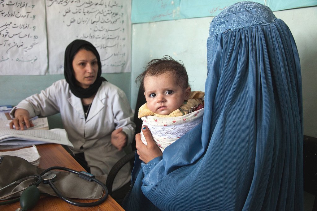 Une sage-femme du dispensaire médical de Sar-e-Hause dans le village de Tajikhan, en Afghanistan, parle avec une mère et son bébé de 5 mois. (archives mai 2012)