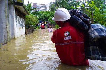 बांग्लादेश में भारी बारिश से प्रभावित लोगों की मदद करते राहतकर्मी.