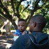 A father holds his son, on a street near his office at the Department of Health in central Cape Town, South Africa. He participated in a UNICEF-supported program that promotes men’s involvement as equitable caregivers.
