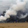 احتراق بئر نفط على يد القوات العراقية في حقول المقوى. في المقدمة توجد بحيرة من النفط بسبب آبار النفط غير المغطاة. 30 آذار/مارس 1991.