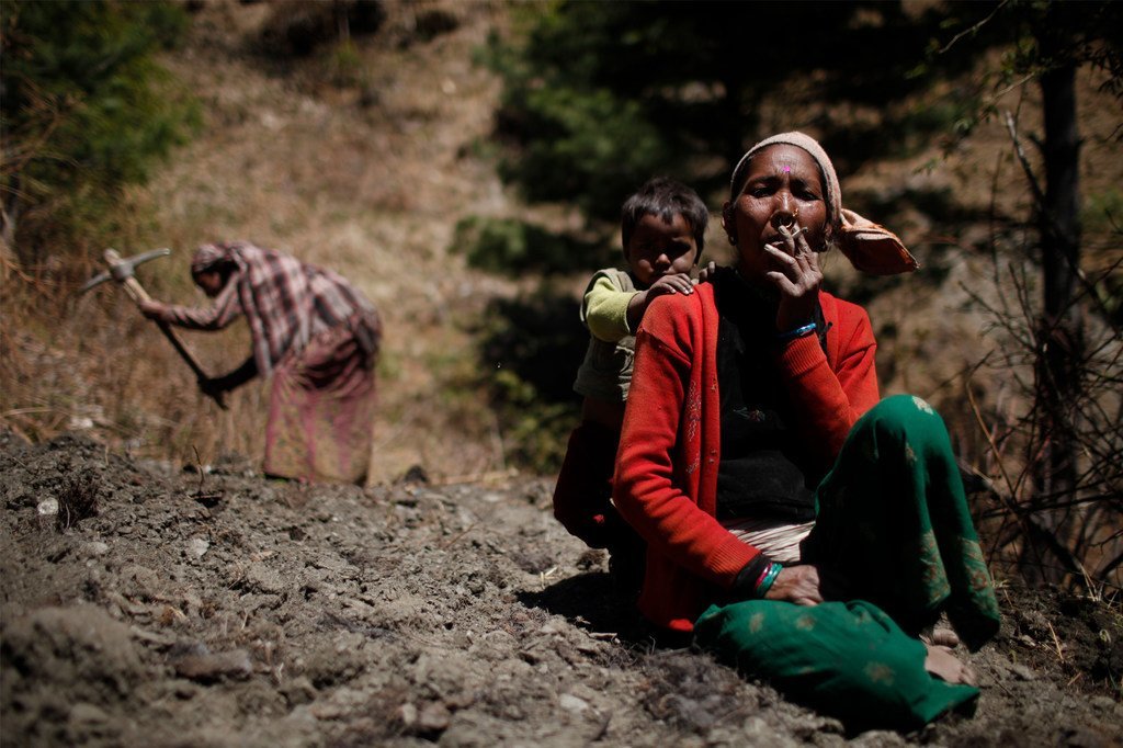 Une femme prend une pause pour fumer une cigarette au Népal.