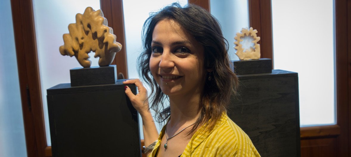 30岁的叙利亚难民艺术家拉莎·迪布与其雕塑作品。