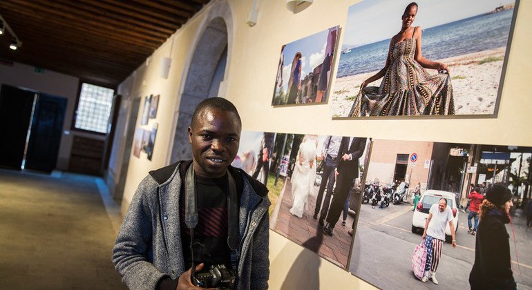 Refugee photographer Mohamed Keita, 25, from Ivory Coast  pictured with his images during the 
