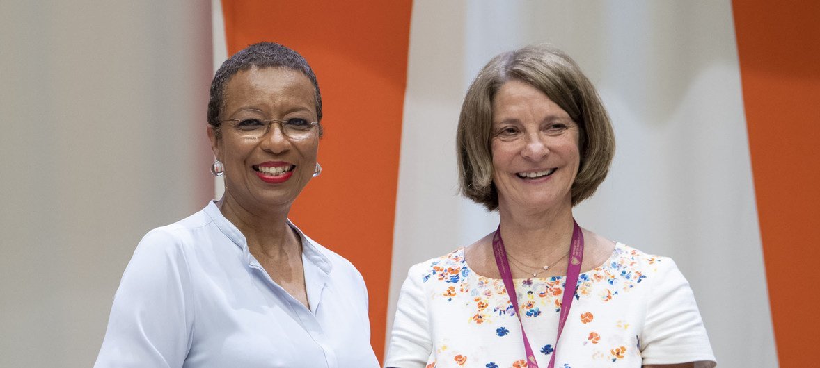 रहोंडा किंग (बाएँ) इकोसॉक की नई अध्यक्ष मोना जुऊल को कार्यभार सौंपते हुए (25 जुलाई 2019)