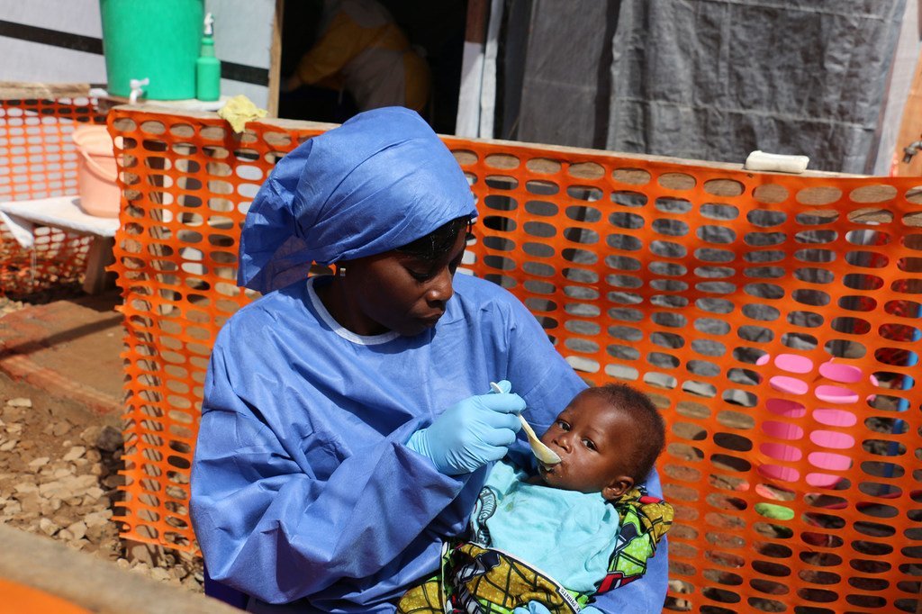 Una trabajadora de salud alimenta un bebé en un centro de tratamiento del ébola en la República Democrática del Congo. 