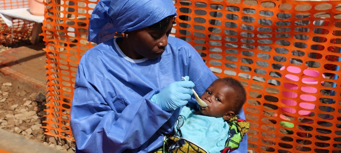 An Ebola health worker in protective gear feeds a baby at an Ebola treatment centre in North Kivu, Democratic Republic of the Congo. (30 January 2019)
