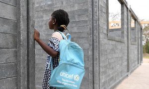 A girl is looking at the construction of her new school made of plastic bricks, in Sakassou, a village in the center of Côte d'Ivoire. ..UNICEF Côte d’Ivoire fights plastic pollution and ensure that every child learns in a supportive environment by buildi