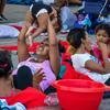 Unas mujeres sentadas con sus hijos entre un grupo de migrantes venezolanos que se han instalado en un espacio público en Huaquillas, Ecuador, después de que fueran rechazados al intentar cruzar la frontera con Perú.